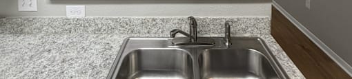 Park at Kirkstall 1-bed kitchen with a granite countertop and stainless steel sink.