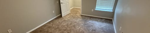 Park at Kirkstall 1-bed bedroom with a carpeted floor and a doorway leading to another room.