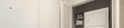 A white door with a handle and a white washing machine in a small laundry room.