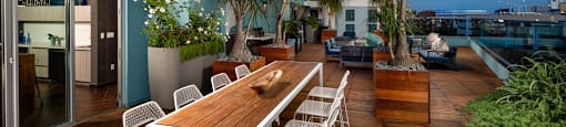 A wooden table with chairs is on a patio.