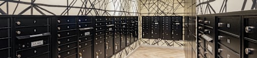 A long hallway with a black and white geometric patterned wall and a wood floor.