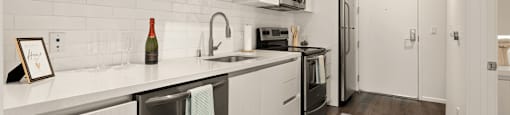 A kitchen with white cabinets and a grey floor.