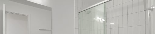 A white bathroom with a toilet, sink, and shower.