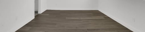 Empty room with a ceiling fan and wooden flooring.