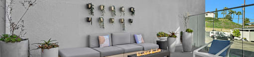 A patio with a couch, chairs, and potted plants.