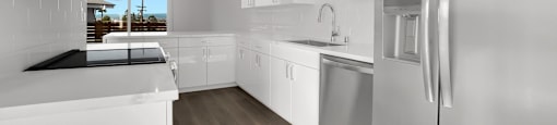 A modern kitchen with white cabinets and stainless steel appliances.
