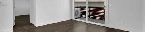 A room with a sliding door leading to a balcony.
