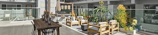 A patio with a table and chairs is surrounded by balconies.
