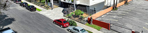 A parking lot with cars and a building in the background. at Bonnie Brae Apartments, Los Angeles