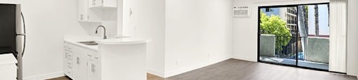 A kitchen with white cabinets and a wooden floor at Bonnie Brae Apartments, Los Angeles, California