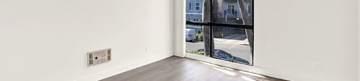 A room with a large window and wooden flooring at Bonnie Brae Apartments, California