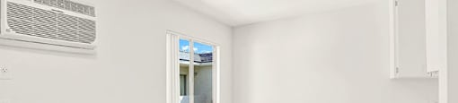 A room with a window and a wall-mounted air conditioner. at Bonnie Brae Apartments, California