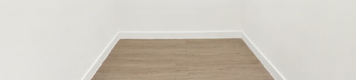 A white empty room with wooden flooring and white walls at Bonnie Brae Apartments, Los Angeles