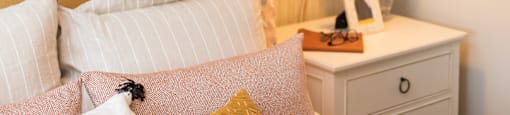 a bedroom with a bed with pillows and a nightstand with a lamp at The Yards at Malvern, Malvern, PA