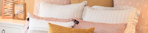 a bedroom with a bed with pillows and pictures on the wall at The Yards at Malvern, Malvern, PA