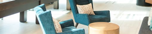 a lobby with blue chairs and a table and windows at The Yards at Malvern, Malvern, PA