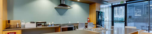 A modern kitchen with a long counter and wooden cabinets.