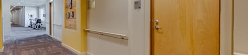 A hallway with a wooden floor and a wooden door.