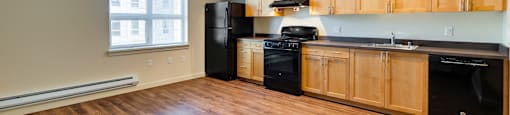 A kitchen with wooden cabinets and black appliances.