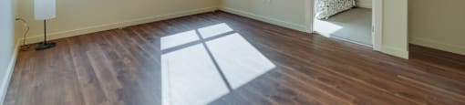 A room with wooden floors and a large window.