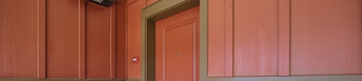 A red door is in a white wall.