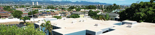Apartment complex with a view of the city in the background.