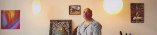 a man sitting on a stool in front of a table
