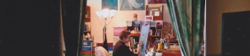 a woman sitting at a desk with a cat in the foreground