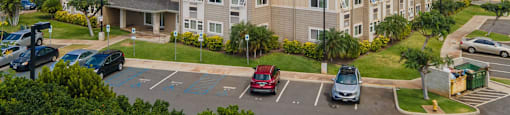a large apartment building with cars parked in a parking lot