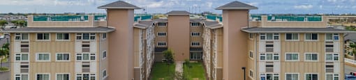 an aerial view of an apartment complex with a blue cloudy sky