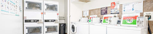 a laundry room with lots of white appliances and a tile floor