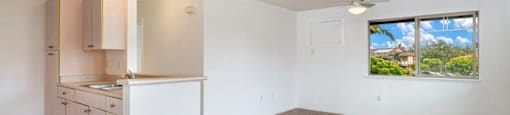 an empty kitchen and living room with a window