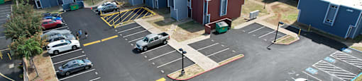 A parking lot with several cars and a building in the background.