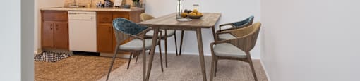 a dining area with a table and chairs and a kitchen in the background at Bedford Castle, Bedford Heights, 44146