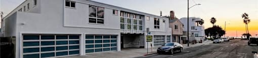 a white building with a car parked on a street