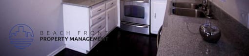 a white kitchen with stainless steel appliances and white cabinets