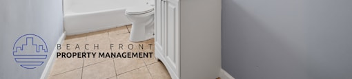 A bathroom with a toilet, sink, and mirror.