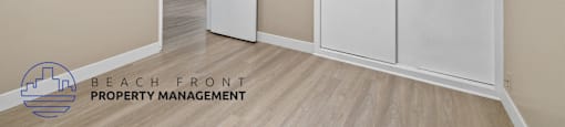 A room with a white door and cabinets, and a logo for Beach Front Property Management.