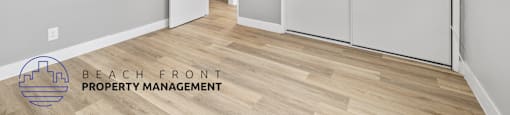 A room with a sliding door and a logo for Beach Front Property Management.