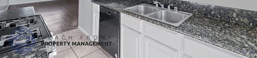 A kitchen with granite countertops and white cabinets.