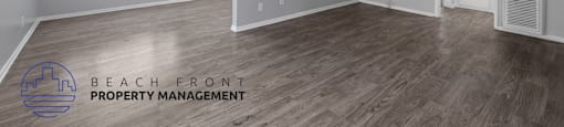 the spacious living room with hardwood flooring and a ceiling fan