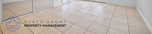 the living room and dining room of a house with white walls and tiled floors