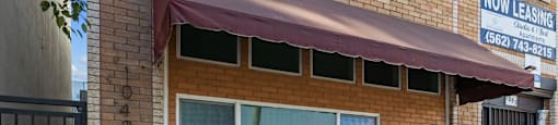 the front of a brick building with a window and a white door