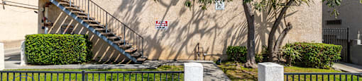 A building with a tree in front and a sign that says "Property Management".