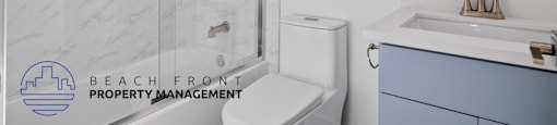 A bathroom with a toilet, sink, and mirror.