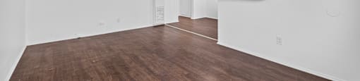 Empty room with white walls and wooden floor.