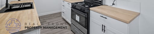 A kitchen with white cabinets and a wooden countertop.