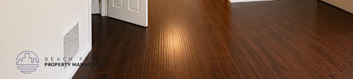 A room with a white door and wooden floors.