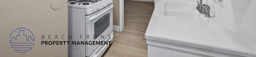 A kitchen with a stove, sink and cabinets.