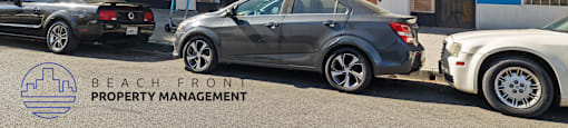 the front of the beach front property management office with cars parked outside